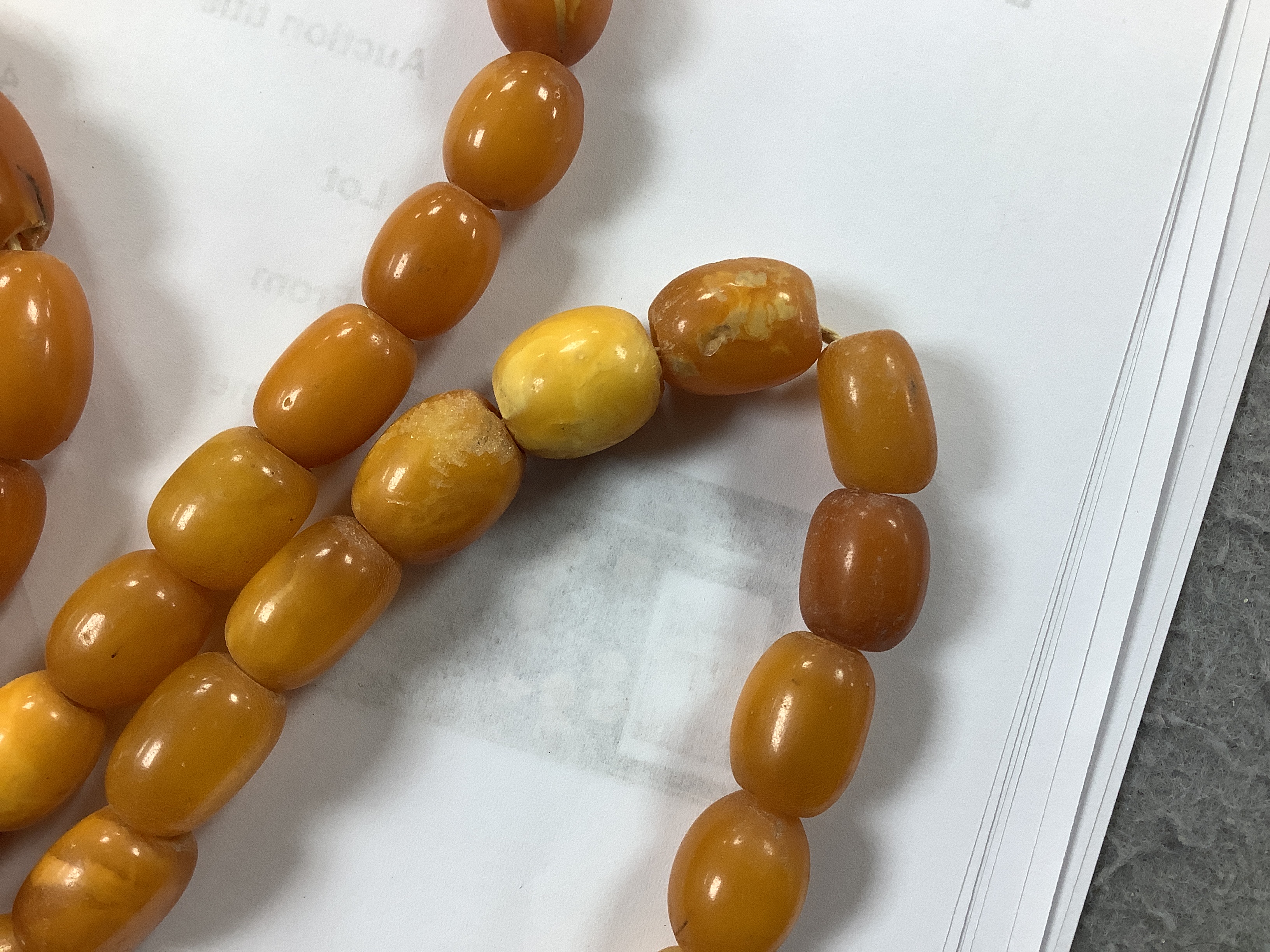 A single strand, barrel and oval amber bead necklace, 108cm, gross weight 76 grams.